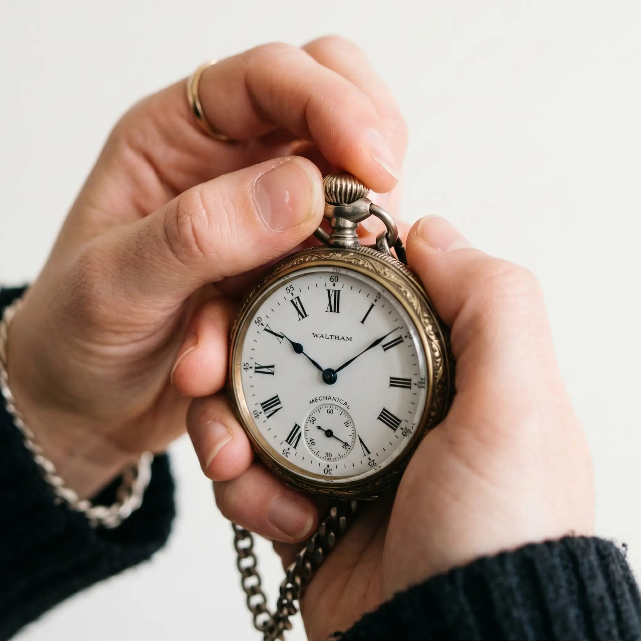 Hand winding the crown of a classic mechanical pocket watch Image