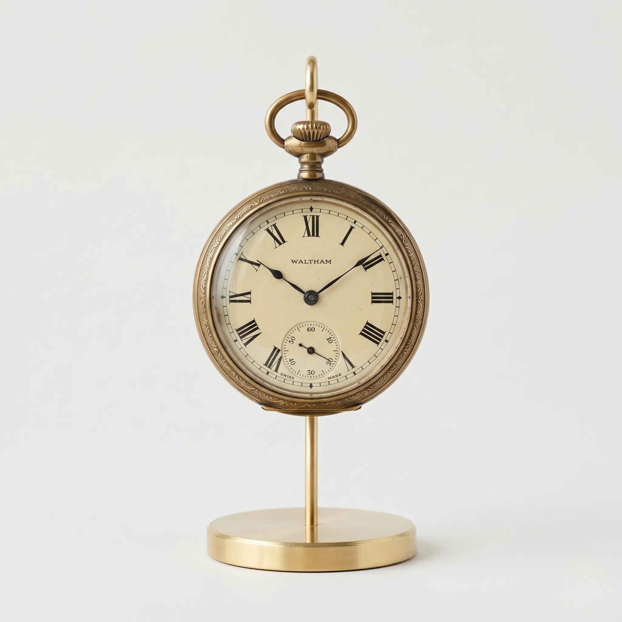 Vintage pocket watch displayed upright on a polished brass pocket watch stand Image