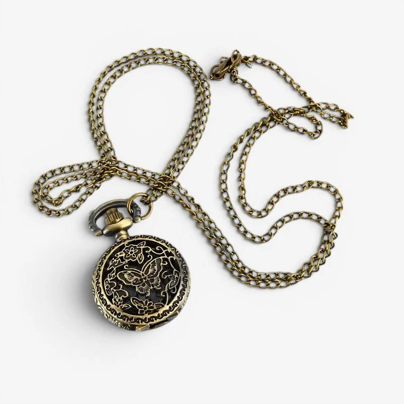 Antique butterfly pocket watch in brass with intricate butterfly and floral engravings on darkened face suspended from ornate chain