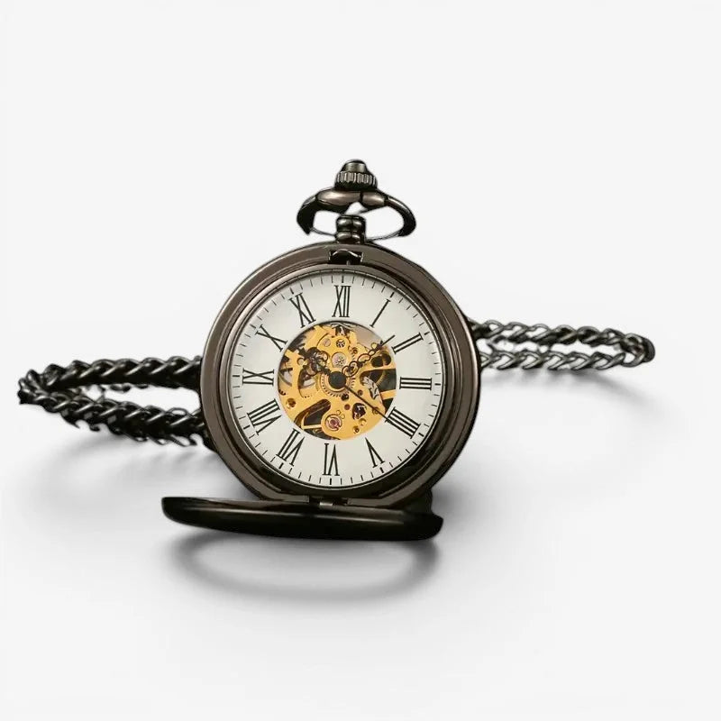 Antique mechanical pocket watch with dark metallic case white face roman numerals and exposed golden movement