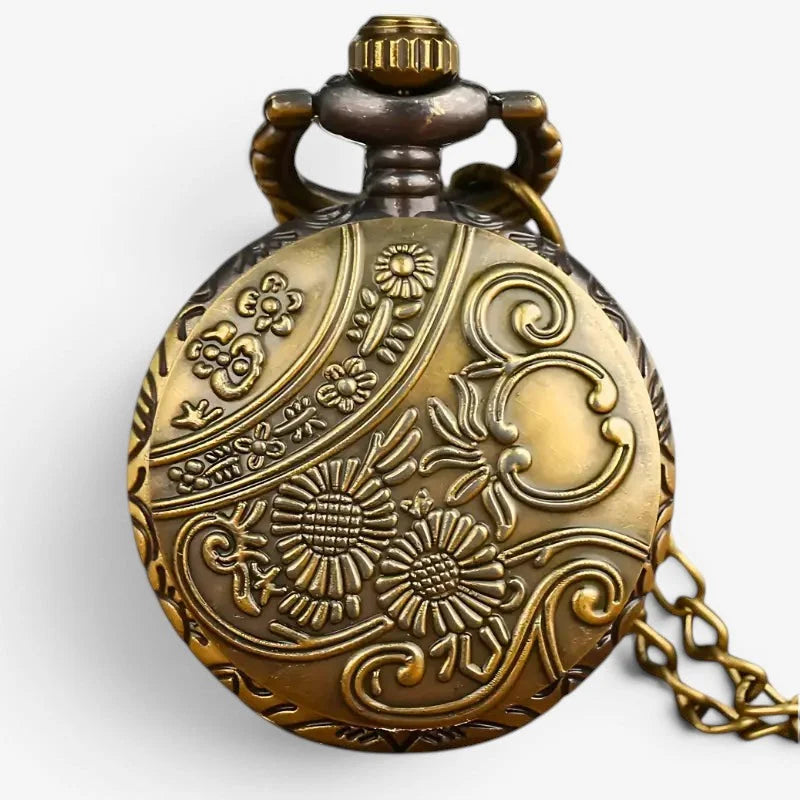 Antique pocket watch necklace in brass with intricate floral and scrollwork engraving and decorative crown top with chain