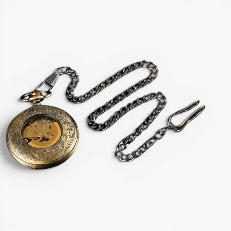 Antique gold-toned automatic pocket watch with intricate engravings exposed brass gears and dark silver chain clip