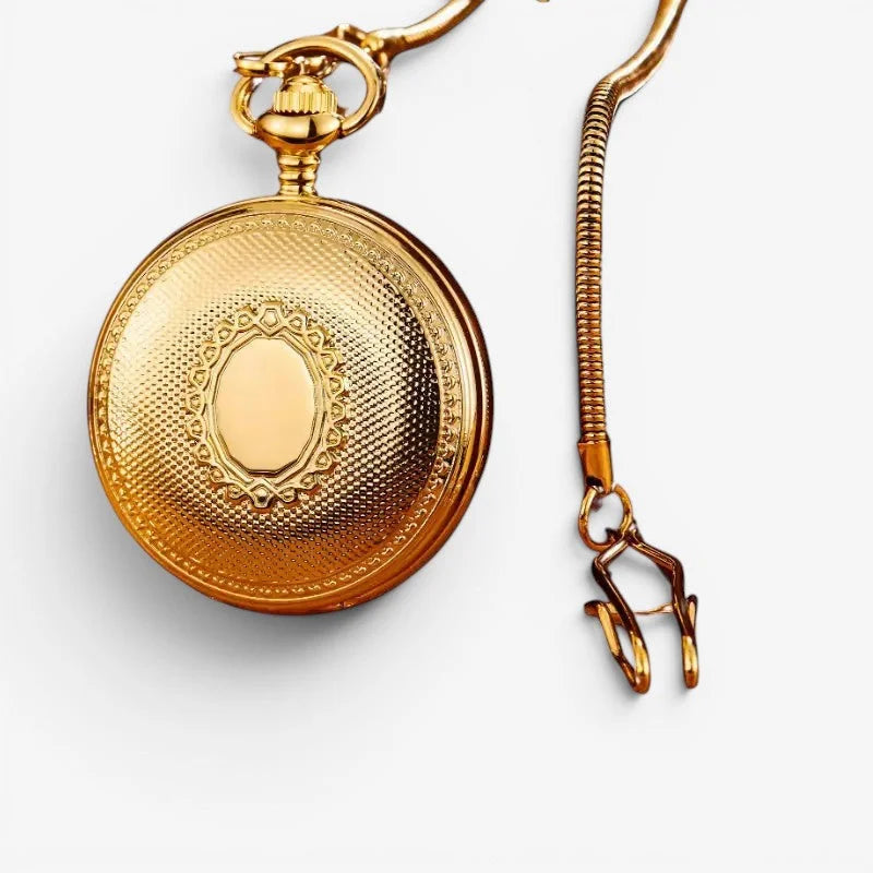 Golden automatic pocket watch with intricate engraved patterns and ornate oval centerpiece on textured surface
