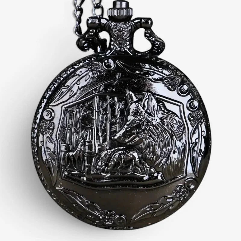 Black ornate pocket watch with a detailed wolf and forest scene engraved on its face featuring a black wolf motif