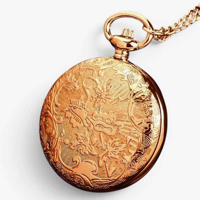 Bronze open compass pocket watch with golden intricate floral and scrollwork engraving attached to a gold chain