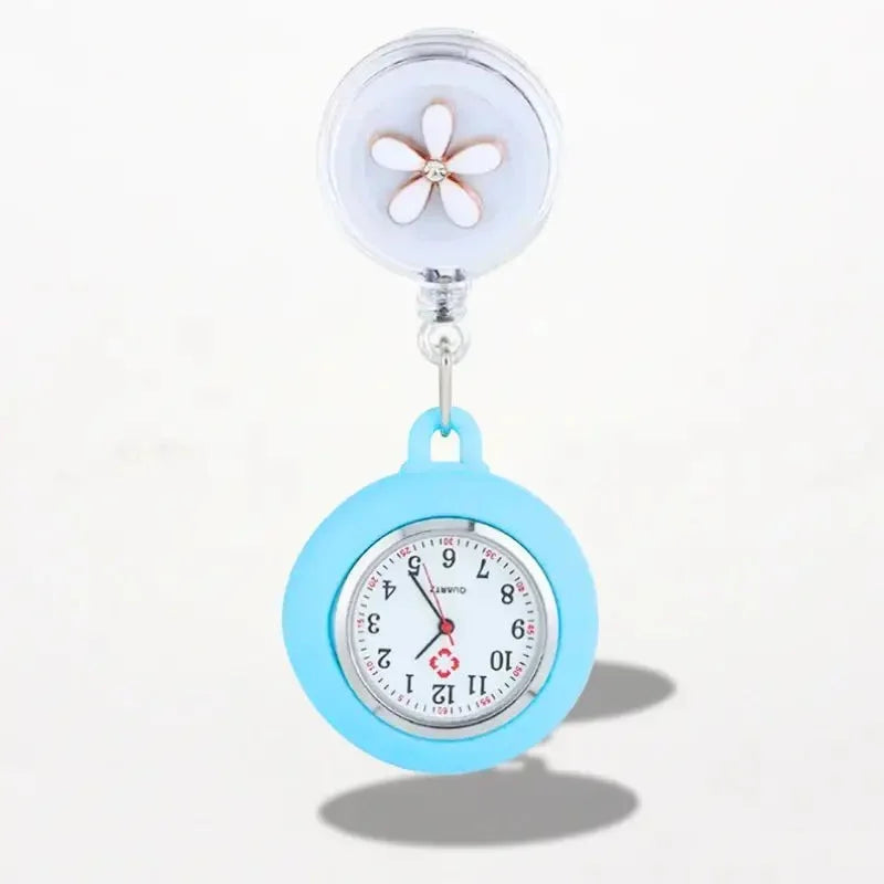 Light blue silicone-coated clip on nurse watch with retractable feature and clear plastic top with white flower design