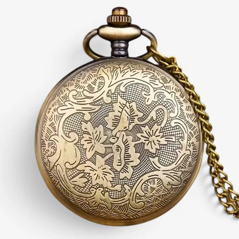 Antique brass cross pocket watch with intricate floral and vine engraving on face attached to gold-toned chain
