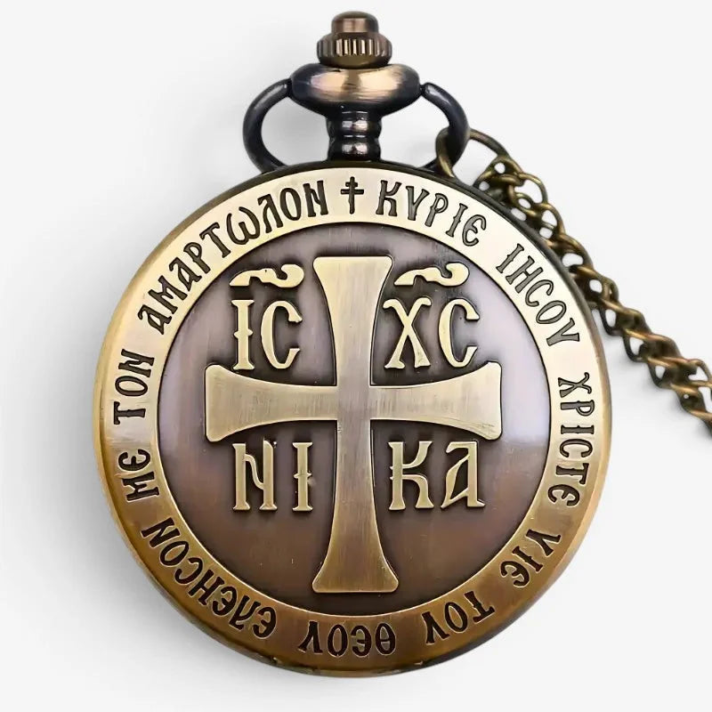Antique bronze-colored cross pocket watch with raised cross and Greek inscriptions on circular face