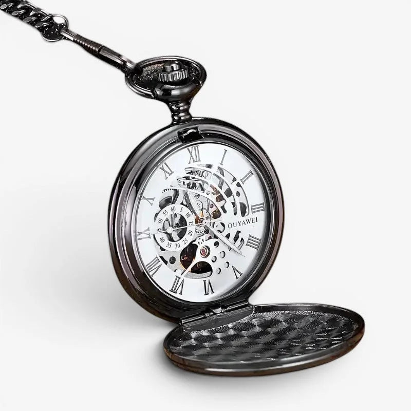 Black skeleton pocket watch with roman numerals and visible mechanical movement featuring an ornate chain attachment