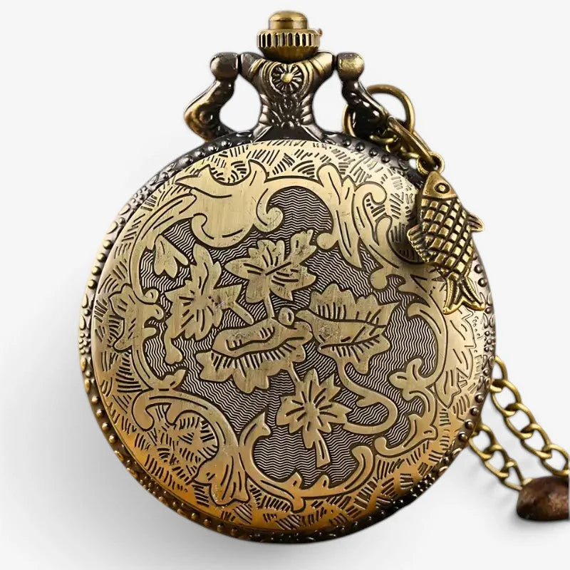 Antique brass fisherman pocket watch with intricate floral bird engravings and a small fish charm on its chain
