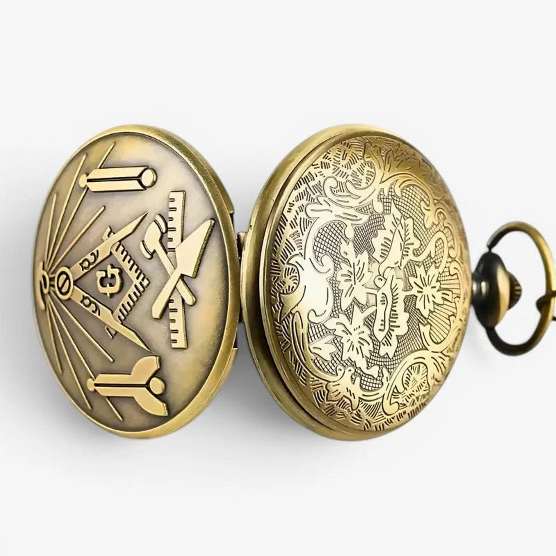 Antique brass-finished free mason pocket watch showing back side with intricate engraved masonic and floral patterns