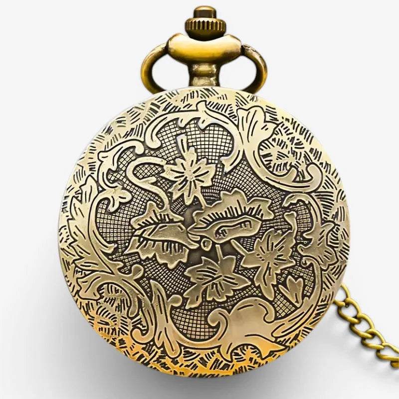 Antique brass gear pocket watch with intricate floral and scrollwork engraving on its circular face and matching chain