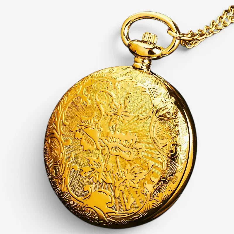 Gold open compass pocket watch with intricate floral and scrollwork engraving on gold case attached to matching chain