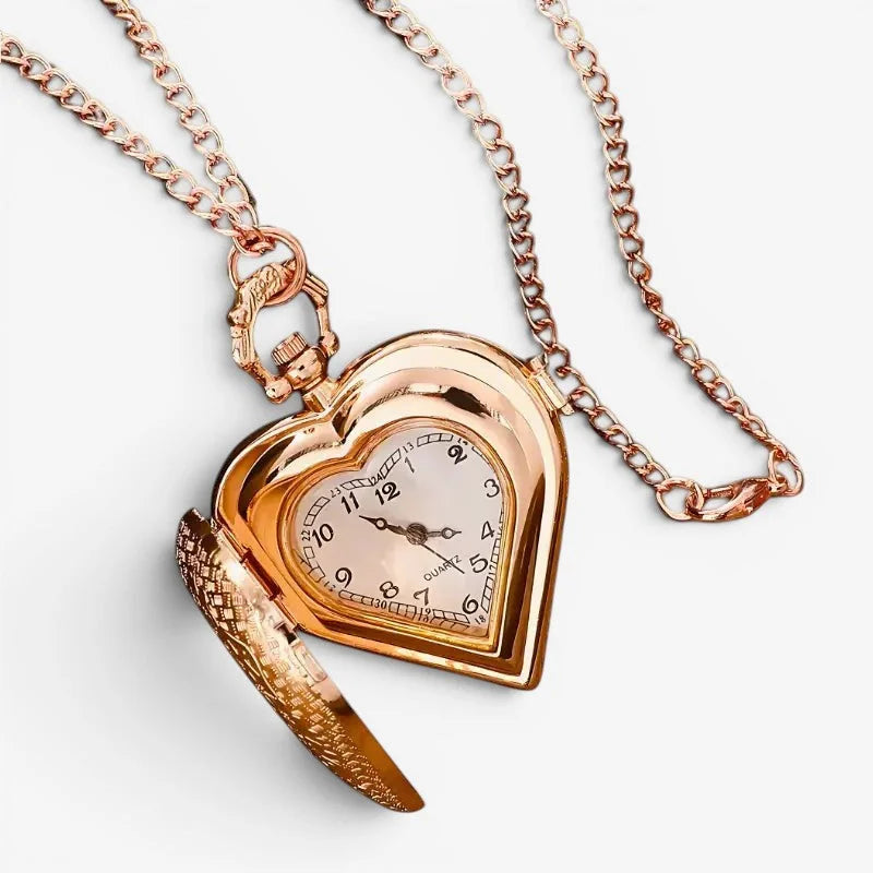 Rose gold heart pendant watch with quartz movement and open face showing black numerals on cream dial with chain