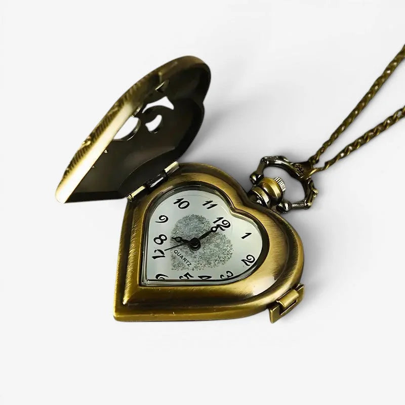 Antique brass heart pocket watch with quartz movement black numerals suspended from an ornate chain