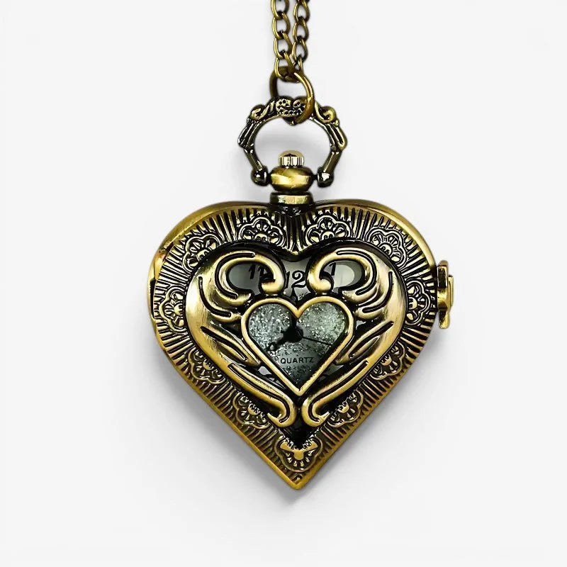 Antique gold heart pocket watch with intricate filigree detailing and visible quartz movement in a locket style