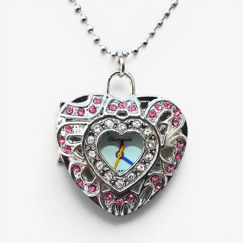 A silver heart watch necklace locket with pink and clear rhinestones and a light blue face with yellow hand