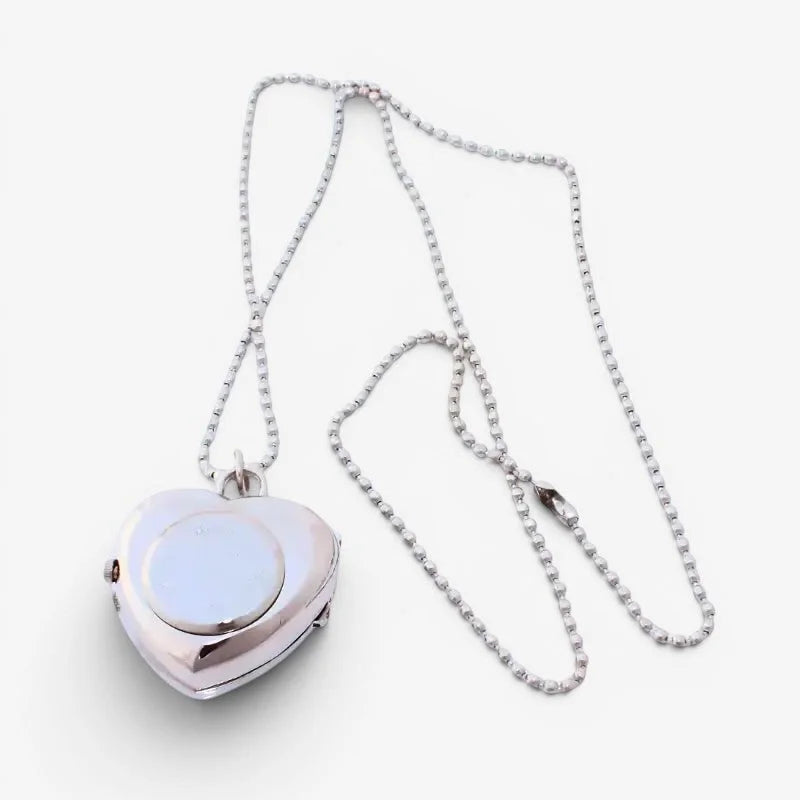 Silver heart watch necklace with smooth reflective locket and circular inset panel on silver chain