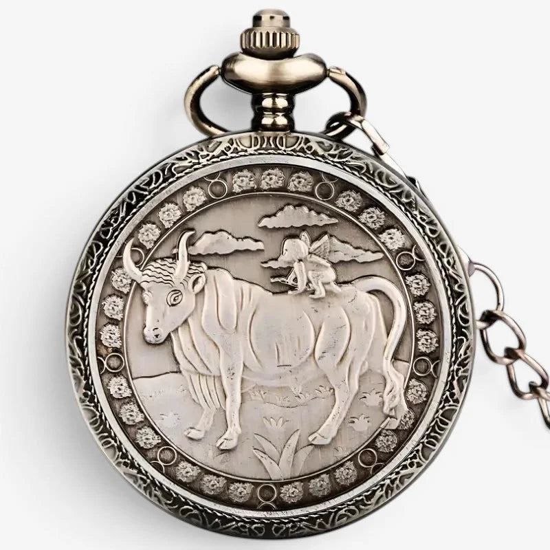 Antique silver-toned horoscope pocket watch back side with intricate engraved bull and ornate floral patterns