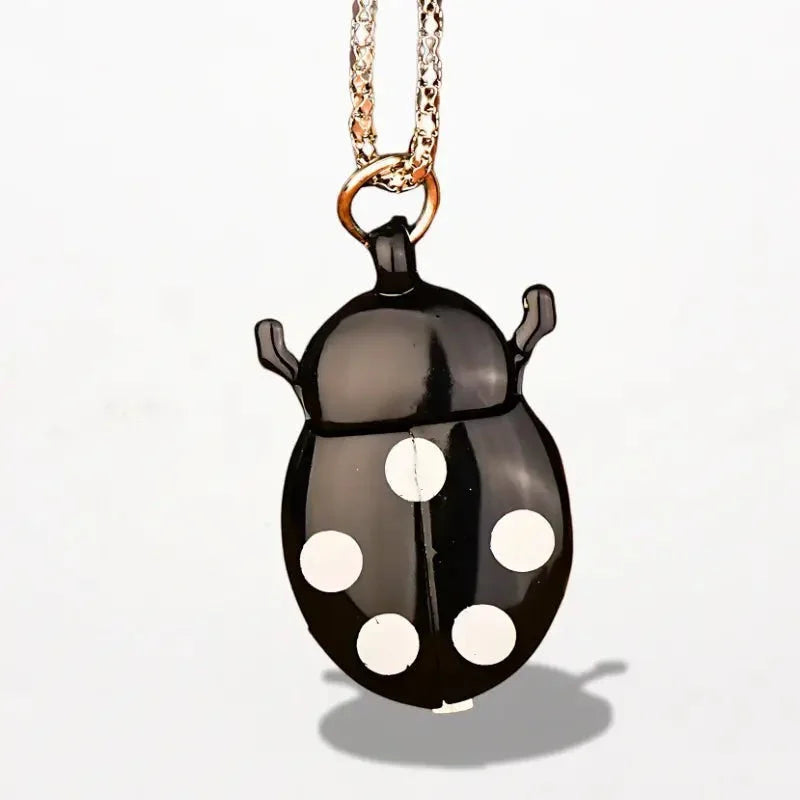 Ladybug nurse watch featuring a black ladybug-shaped locket with white polka dots on a gold-toned chain