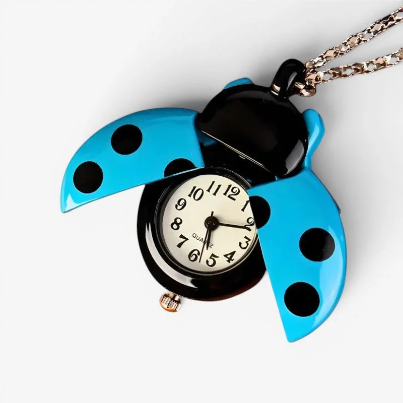 A bright blue ladybug nurse watch pendant with black polka dots quartz face on a silver chain