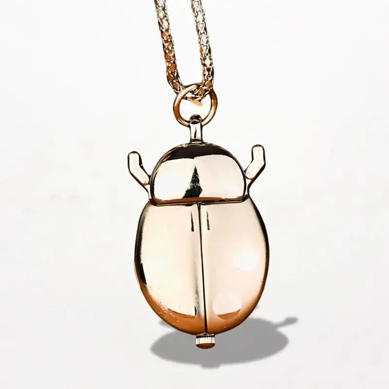 Gold-toned beetle-shaped locket pendant with polished metallic finish and detailed antennae for ladybug nurse watch