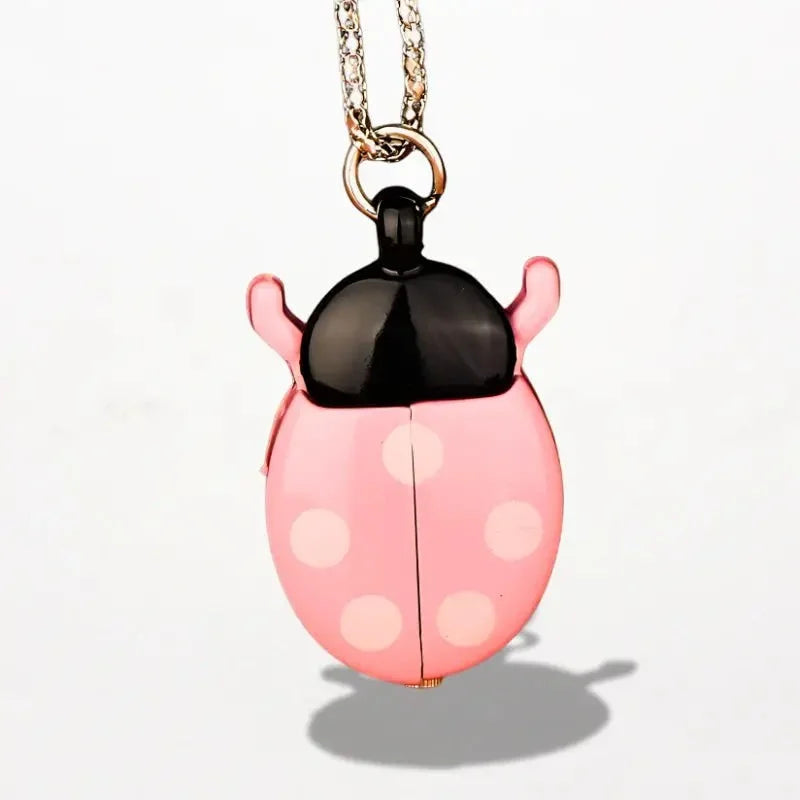 Pink ladybug nurse watch locket with black head white polka dots hanging from gold-toned chain