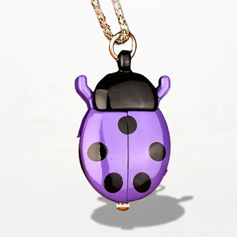 Purple ladybug nurse watch pendant with black spots and glossy finish hanging from gold toned chain