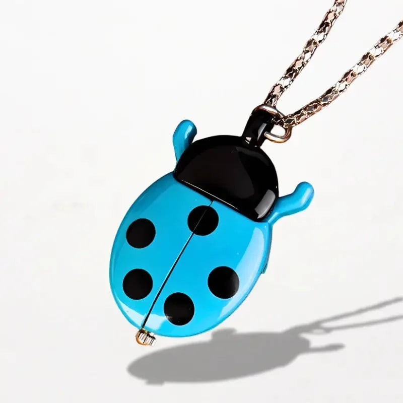 A vibrant blue ladybug nurse watch pendant with black spots and glossy finish on a delicate chain