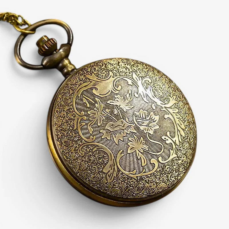 Antique brass magic pocket watch with intricate floral and vine engraving on the back side