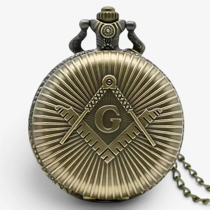 Antique brass masonic pocket watch with detailed emblem featuring crossed tools and the letter g on its face