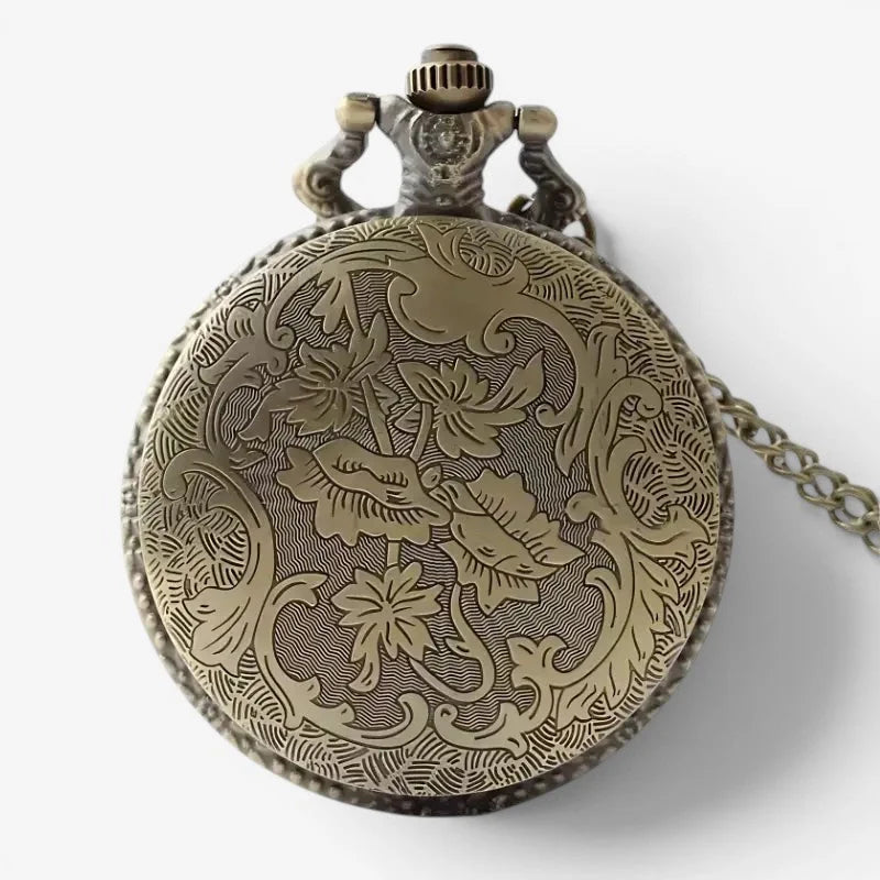 Antique brass masonic pocket watch with intricate floral engraving and attached chain showing front face