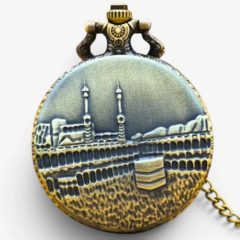 Antique brass-finished pocket watch featuring a detailed relief of the kaaba and surrounding structures on its face
