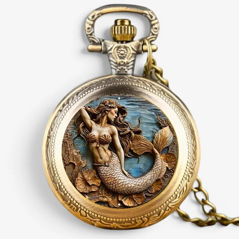 Antique gold-toned mermaid pocket watch with intricate carved scales and flowing hair against blue ocean backdrop