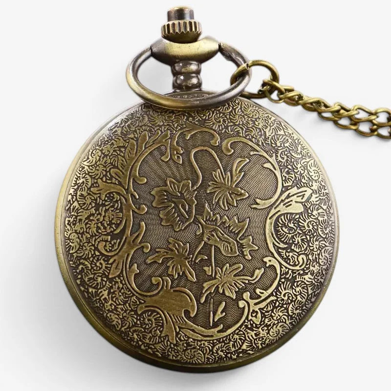 Antique brass mickey pocket watch with intricate floral and scrollwork engraving on circular face and matching chain