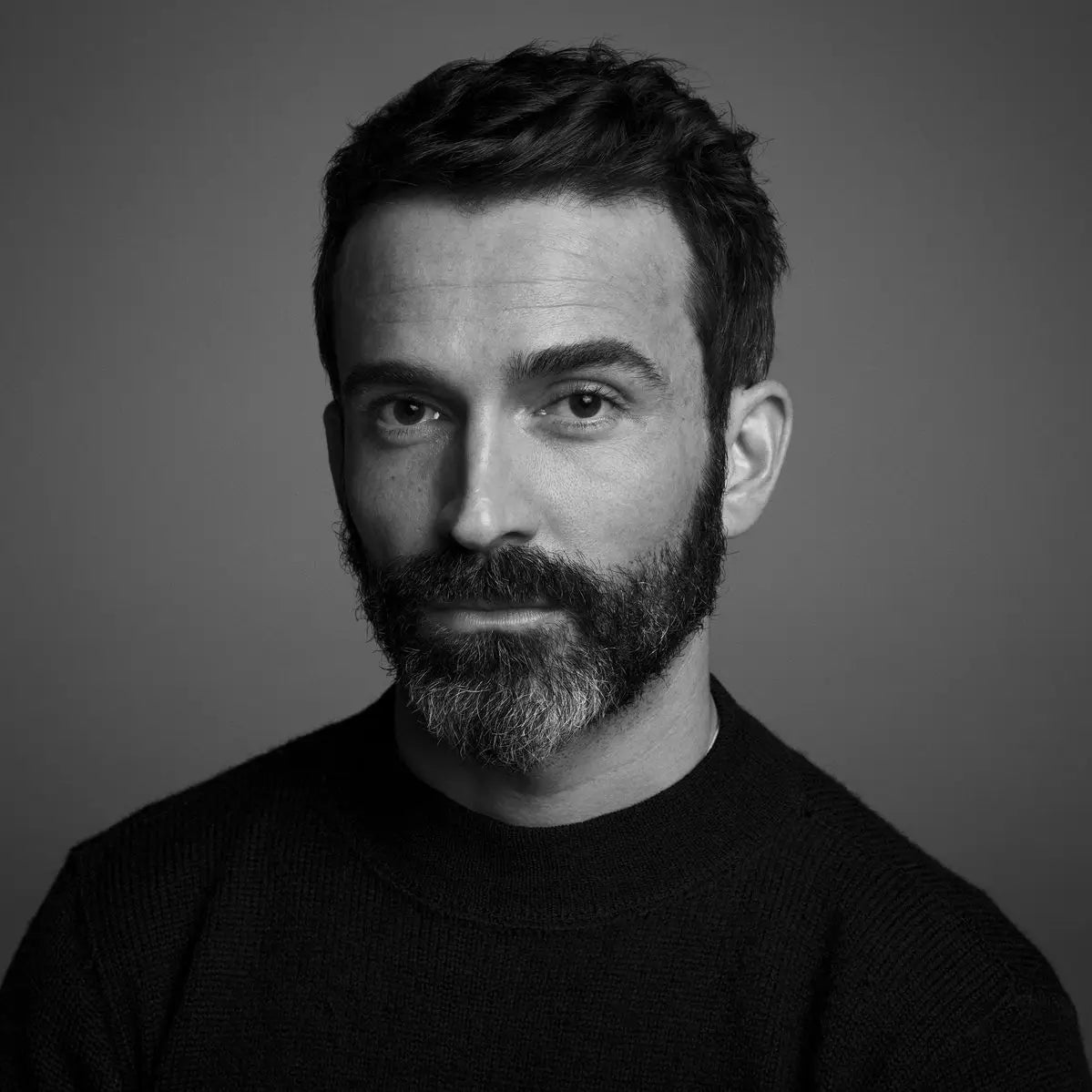 Black and white portrait of a man with a beard against a gray background pocket watch