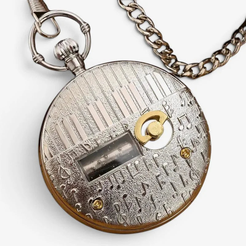 Silver and gold-toned musical pocket watch with piano key and musical note engravings and chain attachment