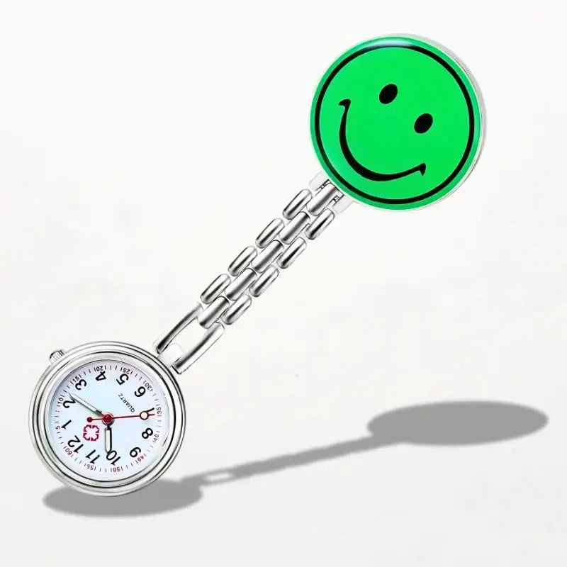 Silver nurse clip watch with white dial black numerals and bright green smiley face charm for easy timekeeping