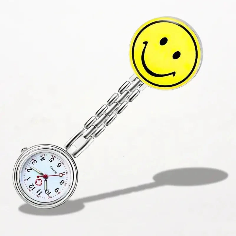 Silver nurse clip watch with white dial black numerals and round yellow smiling face charm
