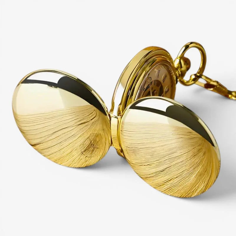 Golden old pocket watch with polished textured surface and an ornate chain for classic timekeeping style