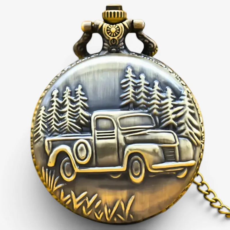 Antique-style brass pickup truck pocket watch with gold-toned accents and detailed vintage truck relief in forest scene