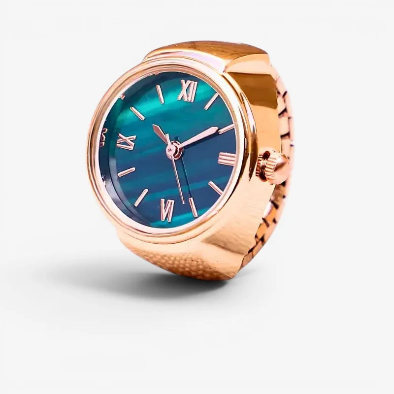 Pink quartz ring watch featuring a rose gold band and teal gradient dial with roman numeral markers