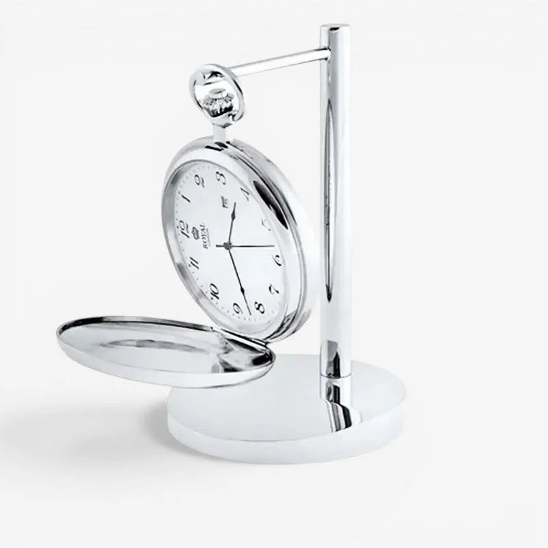 A sleek silver-toned pocket watch with white face and black numerals displayed upright on a chrome stand