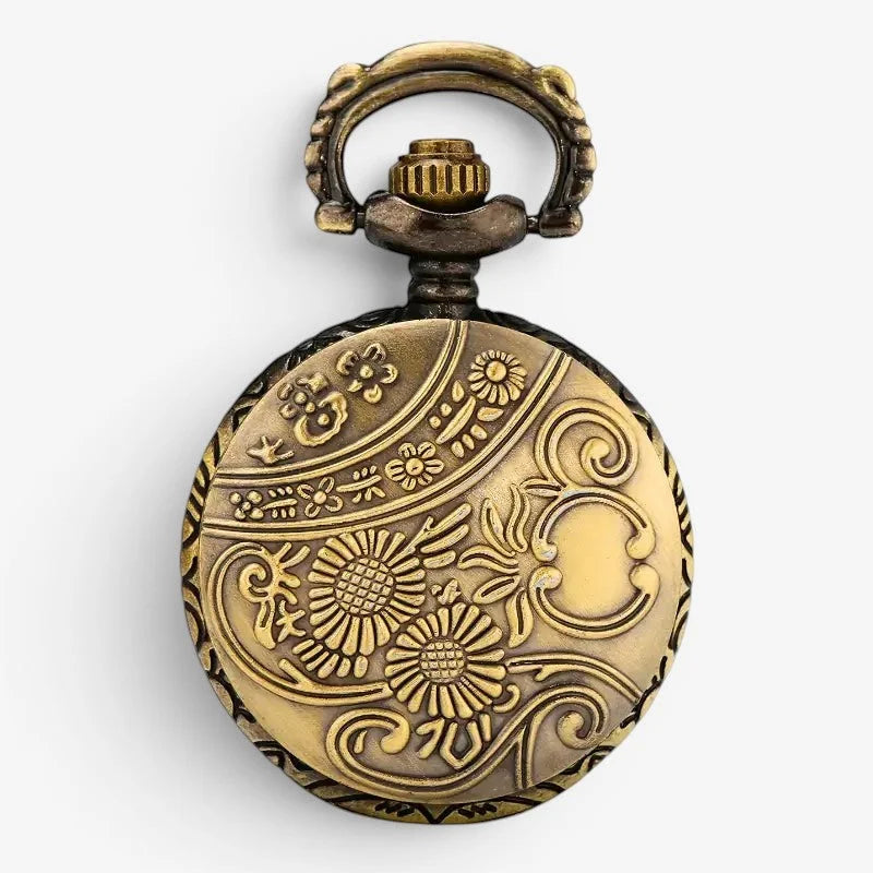 Antique brass pocket watch fob pendant with intricate floral and scrollwork engraving on circular face