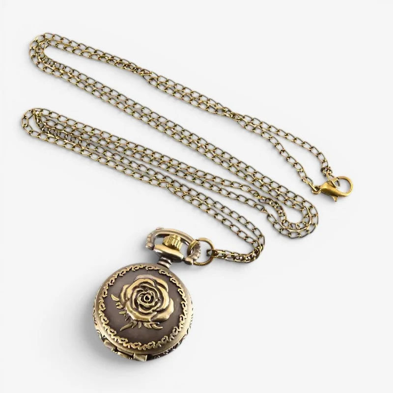 Antique brass pocket watch necklace with detailed rose engraving on a dark brown face hanging from an ornate chain