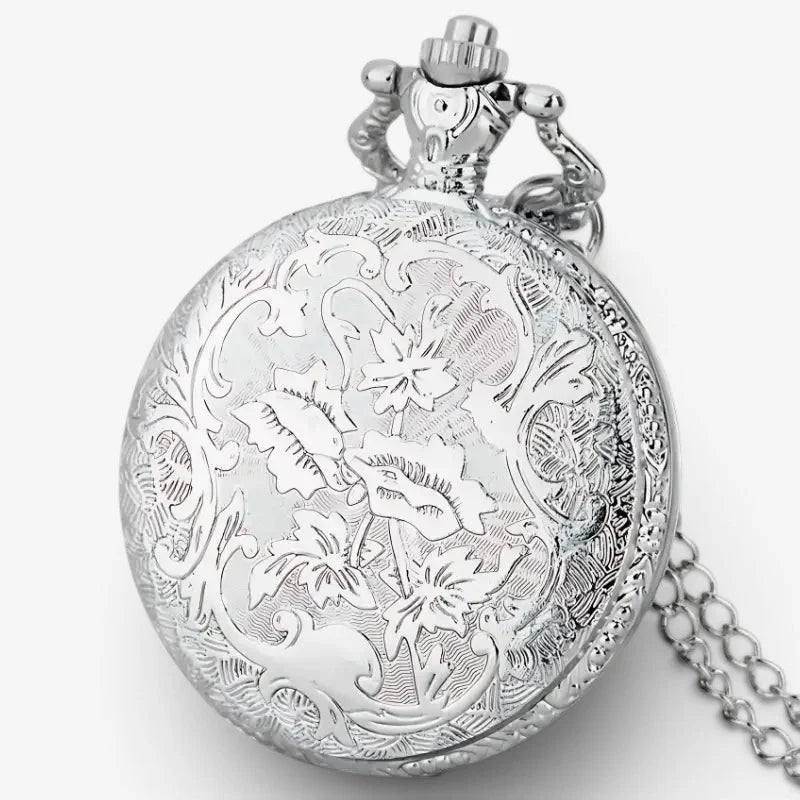 Silver pocket watch with compass features intricate floral engravings and decorative crown-shaped top