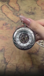 A men's silver mechanical pocket watch displaying its internal gear movement
