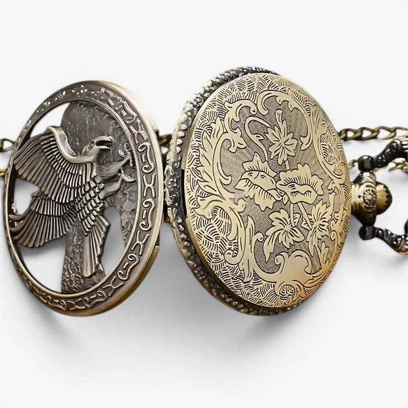 Antique brass quartz eagle pocket watch with an oval locket featuring intricate bird and floral engravings on a chain