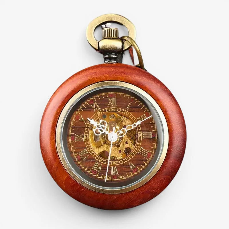 A vintage red wooden pocket watch with gold accents roman numerals and visible intricate internal gears