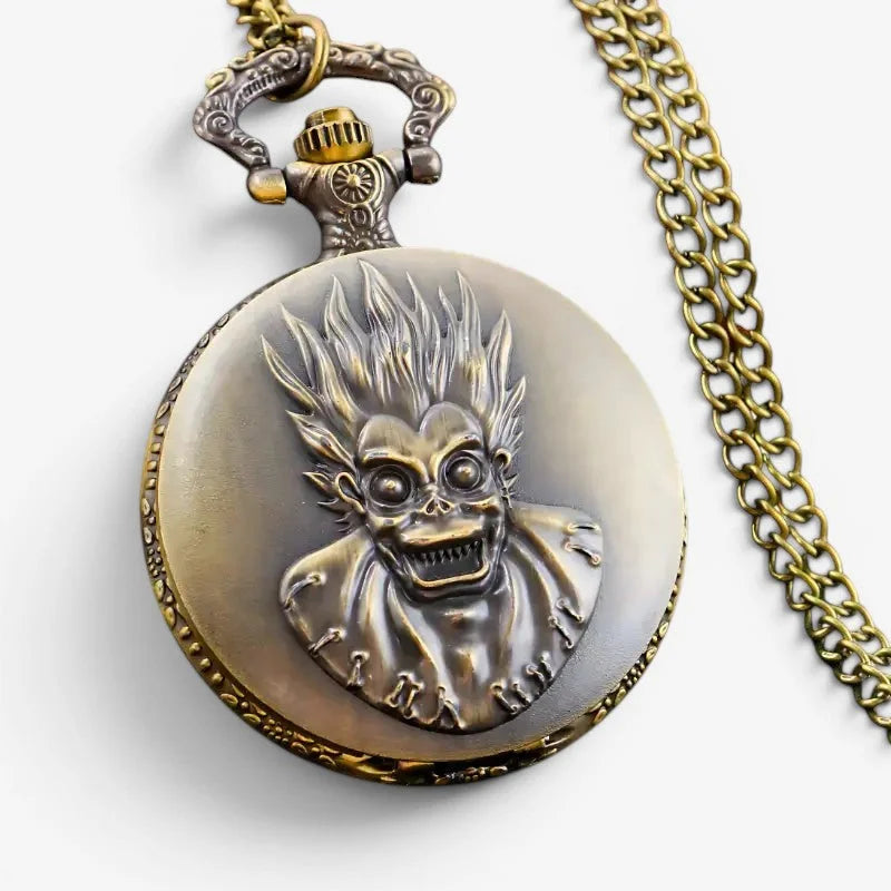 Antique brass-colored ryuk death note pocket watch with detailed embossed design and matching chain